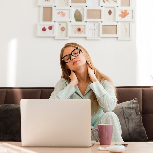 Photo vue de face d'une femme fatiguée en pyjama travaillant à domicile