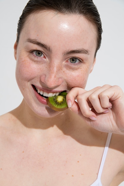 Photo vue de face femme mangeant du kiwi