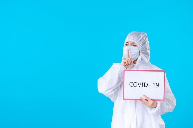 vue de face femme médecin en tenue de protection et masque sur fond bleu couleur covid- virus de la science médicale pandémique de la santé