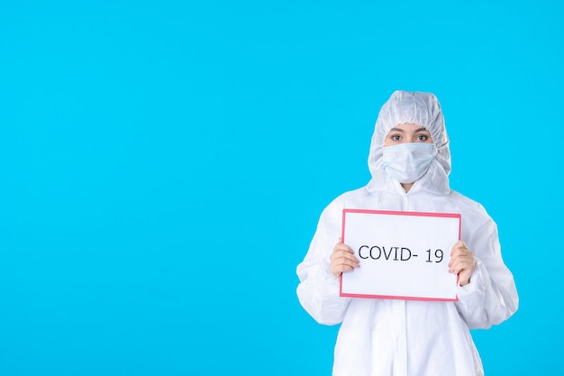 vue de face femme médecin en tenue de protection et masque sur fond bleu covid- science médicale pandémie santé virus isolement couleur