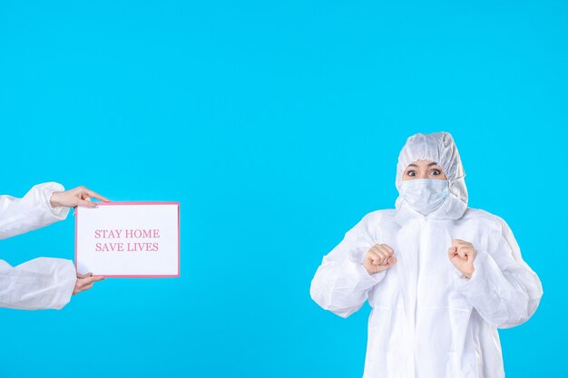 vue de face femme médecin en tenue de protection et masque sur fond bleu isolement covid- science santé virus maladie médicale hâte pandémie