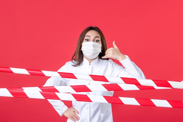 vue de face femme médecin en uniforme médical et masque sur fond rouge ligne pandémique scellée covid- hôpital du virus de la santé