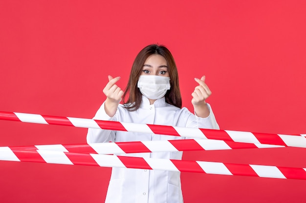 vue de face femme médecin en uniforme médical et masque sur fond rouge scellé virus pandémique - crime de ligne d'hôpital