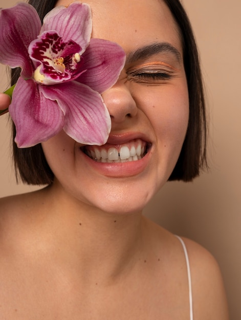 Vue de face femme posant avec fleur