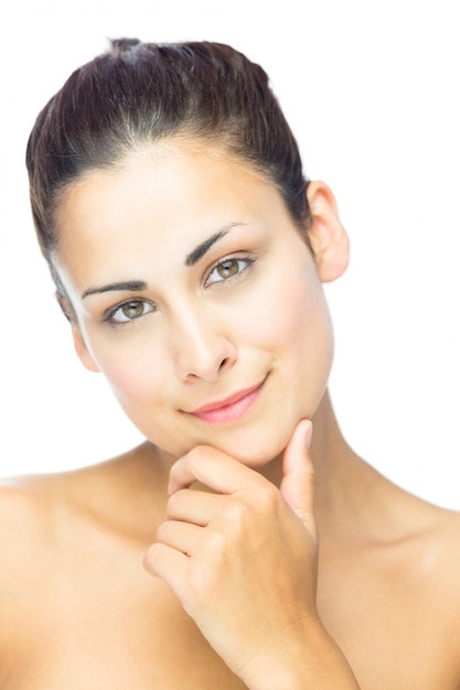 Vue de face d&#39;une femme réfléchie, souriant à la caméra