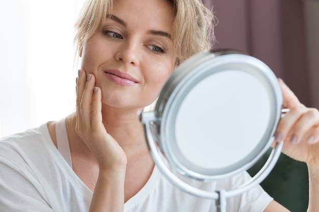 Vue de face femme regardant dans le miroir