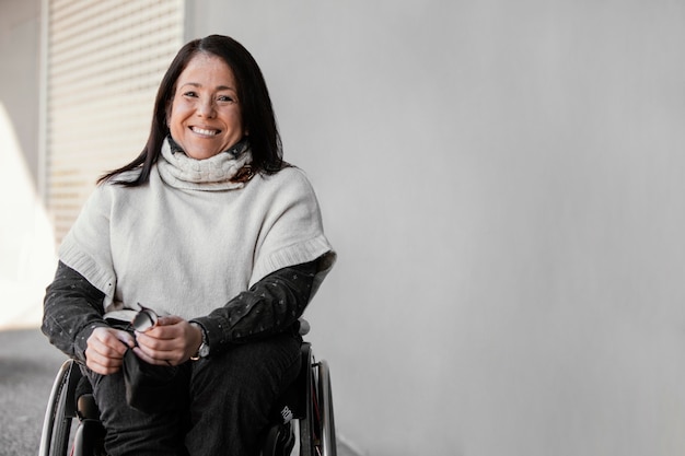 Vue de face de la femme souriante dans un fauteuil roulant avec espace copie