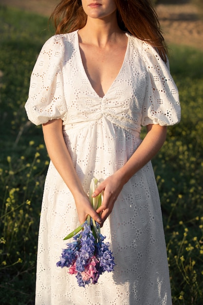 Photo vue de face femme tenant un bouquet de fleurs