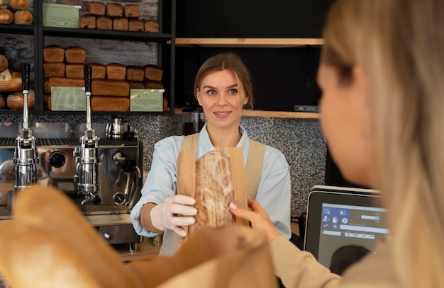 Photo vue de face femme travaillant dans une boulangerie