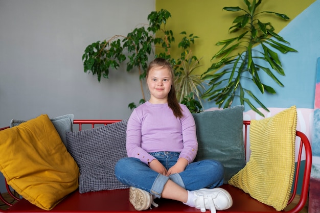 Vue de face fille assise sur le canapé