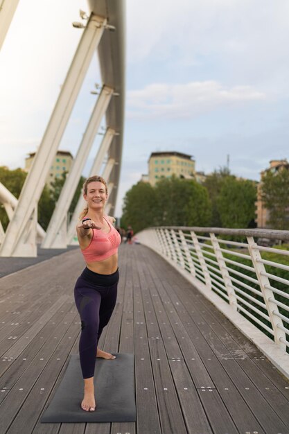 Vue de face de la fille réalisant le yoga au milieu de la pose du guerrier de la ville