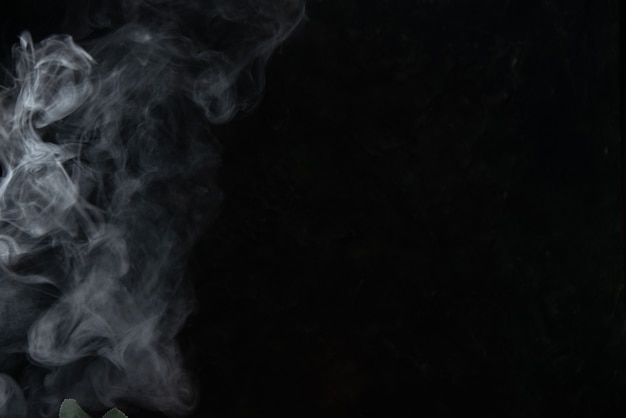 Vue de face de la fumée légère laissée par la bougie sur fond noir