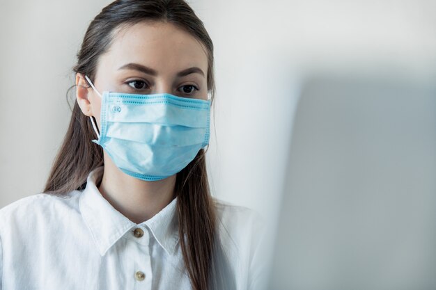 Vue de face gros plan d'une femme dans des verres professionnel de la santé portant un masque chirurgical dans un hôpital. Les travailleurs de la santé dans la pandémie de Coronavirus Covid19