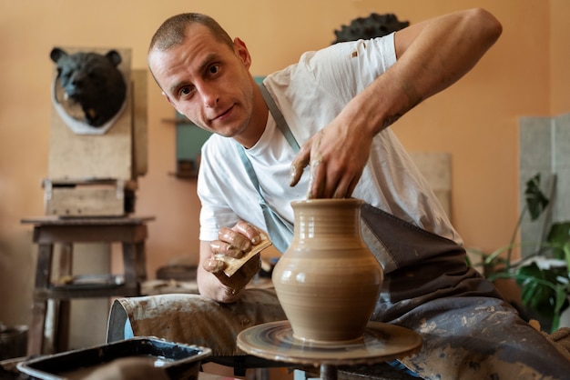 Photo vue de face homme faisant de la poterie