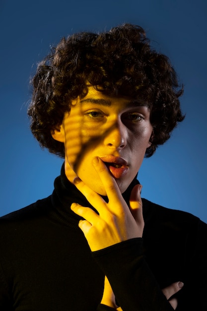 Photo vue de face homme posant en lumière jaune