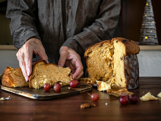 Vue de face de l'homme prenant un morceau de panettone pour le dîner de Noël à la maison Bonbons de Noël