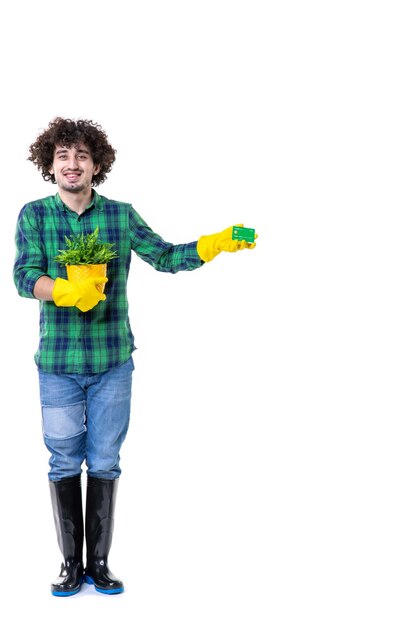 Vue de face jardinier masculin tenant une petite plante et carte bancaire sur fond blanc terrain au sol arbre creuser feuille d'herbe travail de l'eau de jardin