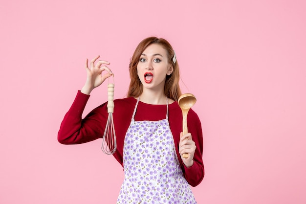 vue de face jeune femme au foyer tenant un fouet et une cuillère en bois sur fond rose tarte de cuisine femme shopping argent cuisine cuisson gâteau