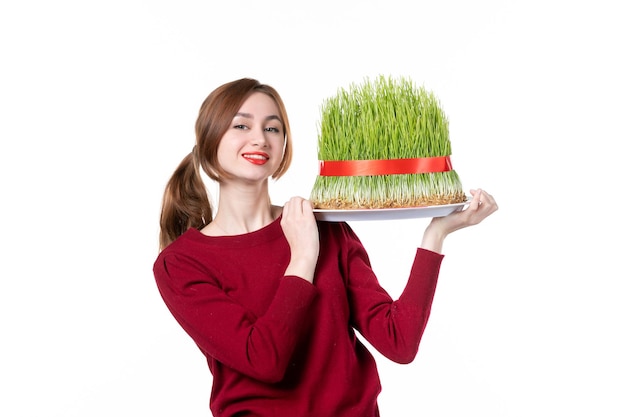 Vue de face jeune femme holding big novruz semeni sur fond blanc printemps famille interprète ethnique couleurs vacances concept d'ethnicité