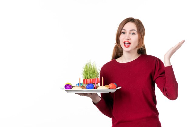 Vue de face jeune femme avec honca avec bonbons semeni et novruz sur fond blanc interprète ethnique couleurs concept vacances en famille printemps