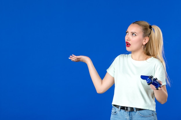 vue de face jeune femme avec manette de jeu sur fond bleu adulte joyeux joueur virtuel internet gagnant vidéo canapé en ligne