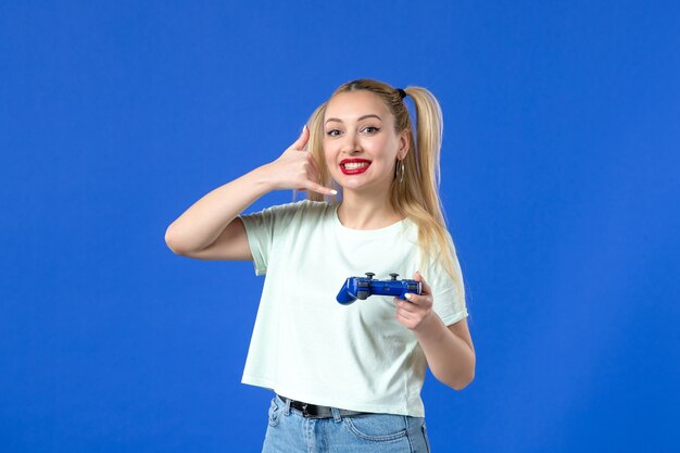 vue de face jeune femme avec manette de jeu sur fond bleu gagnant en ligne joyeuse vidéo joystick adulte joueur virtuel jeunesse