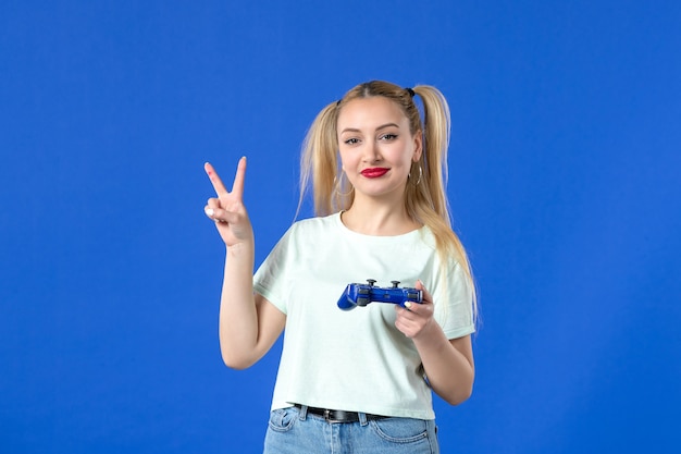 vue de face jeune femme avec manette de jeu sur fond bleu gagnant en ligne joyeuse vidéo joystick virtuel adulte jeunesse