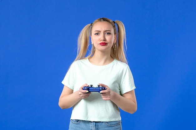 vue de face jeune femme avec manette de jeu sur fond bleu joueur de joie virtuelle en ligne jeunesse joyeuse manette vidéo gagnante adulte