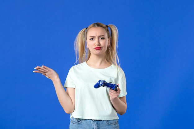 vue de face jeune femme avec manette de jeu sur fond bleu joueur de joystick vidéo en ligne joyeux gagnant jeunes adultes virtuels