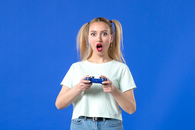 vue de face jeune femme avec manette de jeu sur fond bleu joueur virtuel en ligne adulte jeunesse joyeuse manette vidéo gagnante