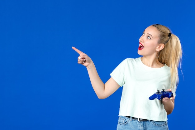 vue de face jeune femme avec manette de jeu sur fond bleu joyeux joueur adulte vidéo jeunesse internet canapé virtuel gagner en ligne