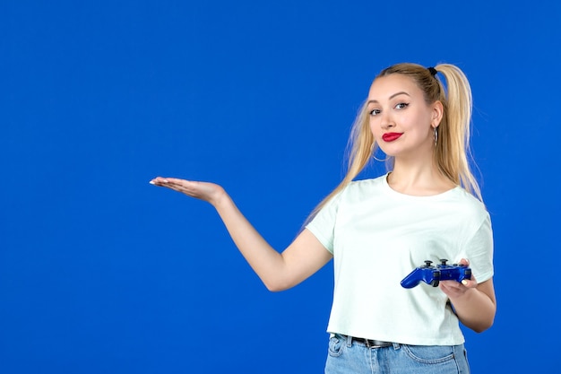 vue de face jeune femme avec manette de jeu sur fond bleu joyeux joueur adulte virtuel vidéo jeunesse canapé gagner en ligne