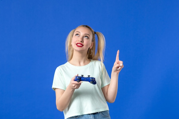 vue de face jeune femme avec manette de jeu sur fond bleu joystick vidéo joyeuse joueur adulte gagnant des jeunes en ligne