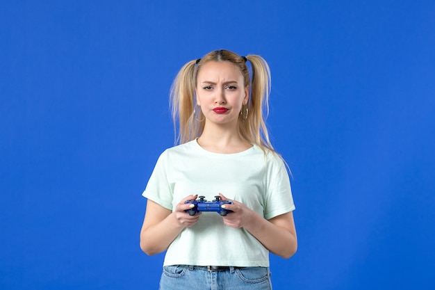 vue de face jeune femme avec manette de jeu sur fond bleu joystick vidéo virtuel jeunesse joueur adulte gagnant en ligne