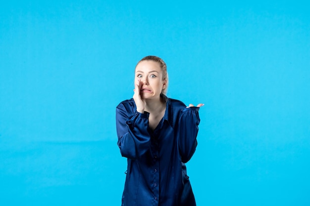 Vue de face jeune femme en pyjama sur fond bleu couleur sommeil lit cauchemar rêve nuit nuit fatigué reste femme bâillement