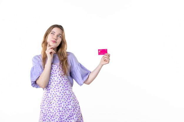 vue de face jeune femme tenant une carte bancaire rose sur fond blanc argent fleur herbe plantes femme couleur shopping garden