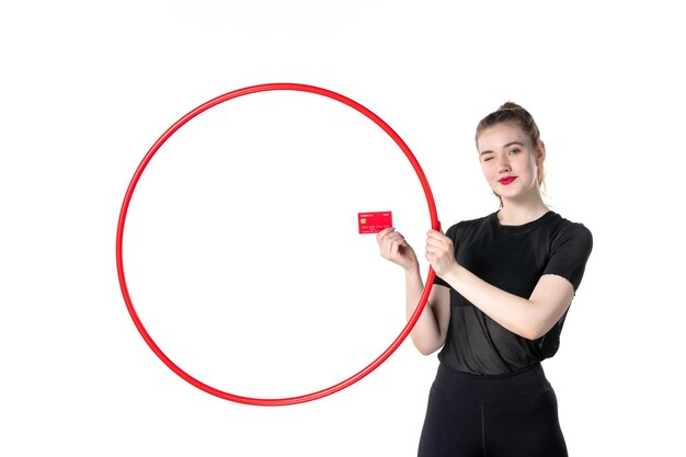 vue de face jeune femme tenant cerceau et carte bancaire sur fond blanc yoga corps style de vie sport santé athlète cirque argent gym