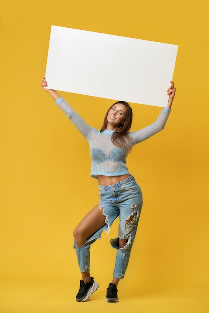 Vue de face d'une jeune fille souriante tenant un bureau