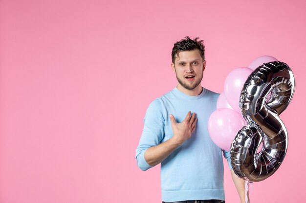 vue de face jeune homme avec des ballons mignons en mars présent sur fond rose féminin journée des femmes amour sensuel mariage égalité date parc amusement