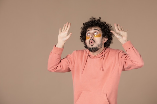 vue de face jeune homme avec cache-œil sur fond marron beauté spa peau massage crème de soin de la peau horizontale