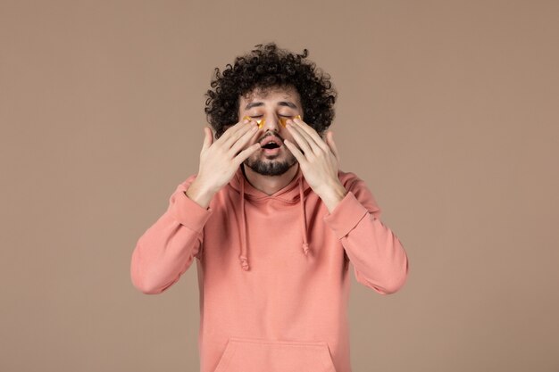 vue de face jeune homme avec cache-œil sur fond marron massage de la peau soins de la peau spa horizontal