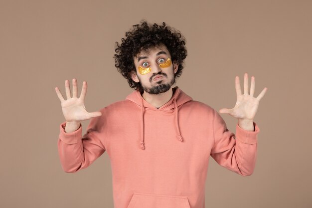 vue de face jeune homme avec cache-œil sur fond marron massage soins de la peau spa beauté de la peau