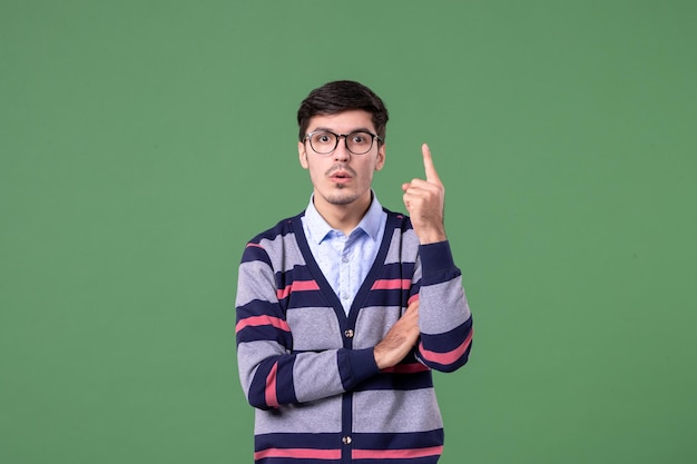 vue de face jeune homme enseignant sur fond vert travailleur bibliothèque couleur travail leçon livre école femme étudiants