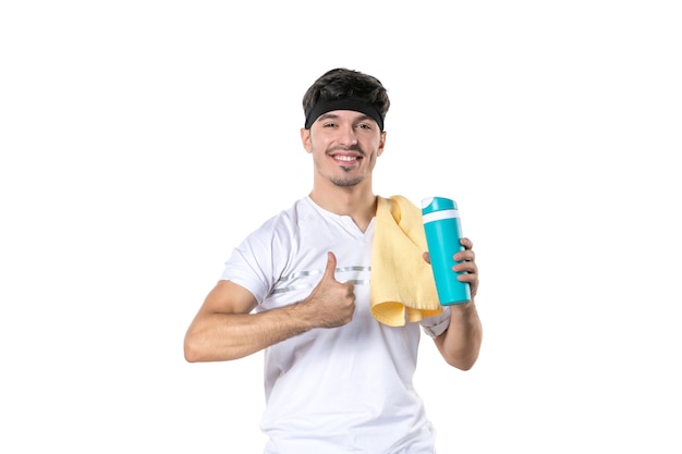 Vue de face jeune homme holding thermos après séance d'entraînement sur fond blanc athlète de sport sport lifestyle corps régime yoga fit