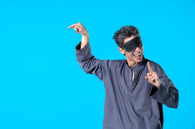 vue de face jeune homme en pyjama et bandage pour dormir sur fond bleu repos sombre cauchemar sommeil lit nuit chambre rêve