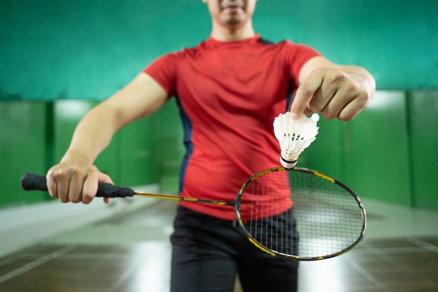Vue de face de joueurs de badminton masculins tenant un volant et une raquette