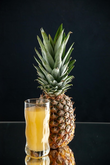 vue de face jus d'ananas frais fruit d'ananas sur fond noir