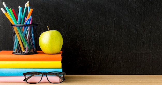 Photo vue de face des livres pour la rentrée scolaire avec des lunettes et copie espace