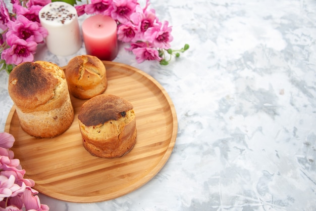 vue de face des oeufs de pâques colorés avec des fleurs et des gâteaux sur fond blanc couleur printemps novruz concept orné