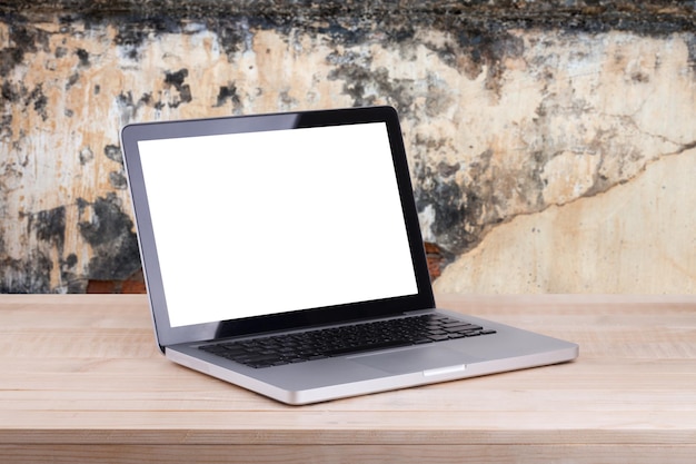 La vue de face de l'ordinateur portable se trouve sur le fond de béton de la table de travail